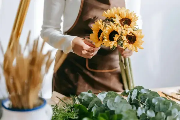 Student is creating bouquet with sunflowers